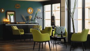 A room with a bar area, green chairs, a table, and decorative items on the walls. - Sure Hotel by Best Western Les Portes de Montauban (Bressols)