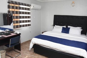 A hotel room with a bed, a desk, and a chair. - Beautiful 1 Bed, Living Room in a Hotel Penthouse (Lekki)