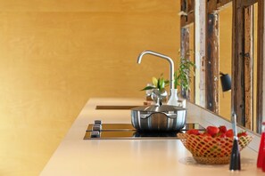 A kitchen counter with a stainless steel pot, a faucet, and a small plant.