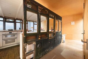 A kitchen with a large window, wooden cabinets, and a stove.