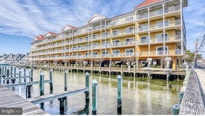 A multi-story hotel with balconies, a waterfront view, and a dock area. - Luxury Waterfront Condo  (Ocean City)