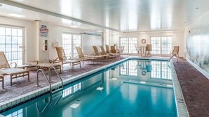 An indoor swimming pool with lounge chairs and a warning sign on the wall. - Luxury Waterfront Condo  (Ocean City)