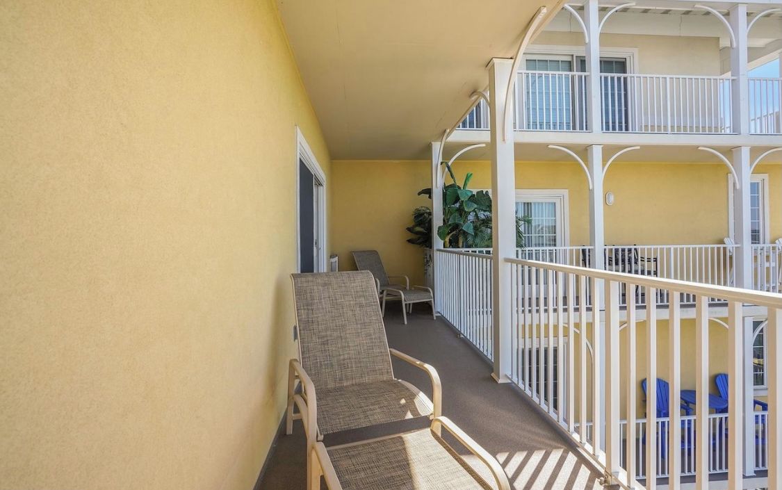 A balcony with a chair, a small table, and a railing.