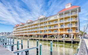 Un hotel de varios pisos con balcones, vista al agua y zona de embarcadero.