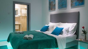 A modern bedroom with a bed, pillows, a nightstand, and artwork on the wall. - Villa Evergreen with Pool (Crikvenica)