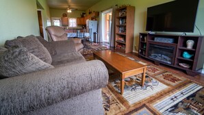 A living room with a sofa, a coffee table, and a television. - The Cascade Mountain-View Retreat (Fort Klamath)