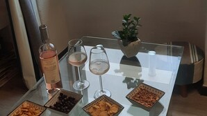 Ett bord med snacks, en flaska vin och utsikt över en kuststad.