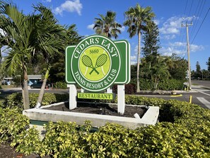 A sign for Cedars East Tennis Resort & Club with a restaurant. - Updated Townhome, Secluded Beach + Pool (Longboat Key)