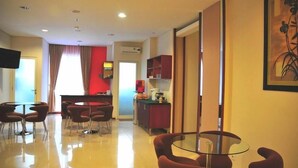 A modern hotel room with a dining area, a kitchen, and a living space. - Thamrin Condotel (Jakarta)