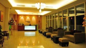 A hotel lobby with a reception desk, seating area, and large windows. - Thamrin Condotel (Jakarta)