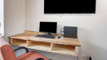 A workspace with a wooden desk, two monitors, a keyboard, and a mouse.