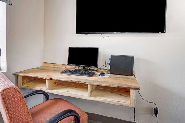 A workspace with a wooden desk, two monitors, a keyboard, and a mouse. - Quality Inn near Mesa Verde (Cortez)