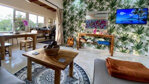 Un salon moderne avec une table basse en bois, un canapé gris et un tapis à motifs.