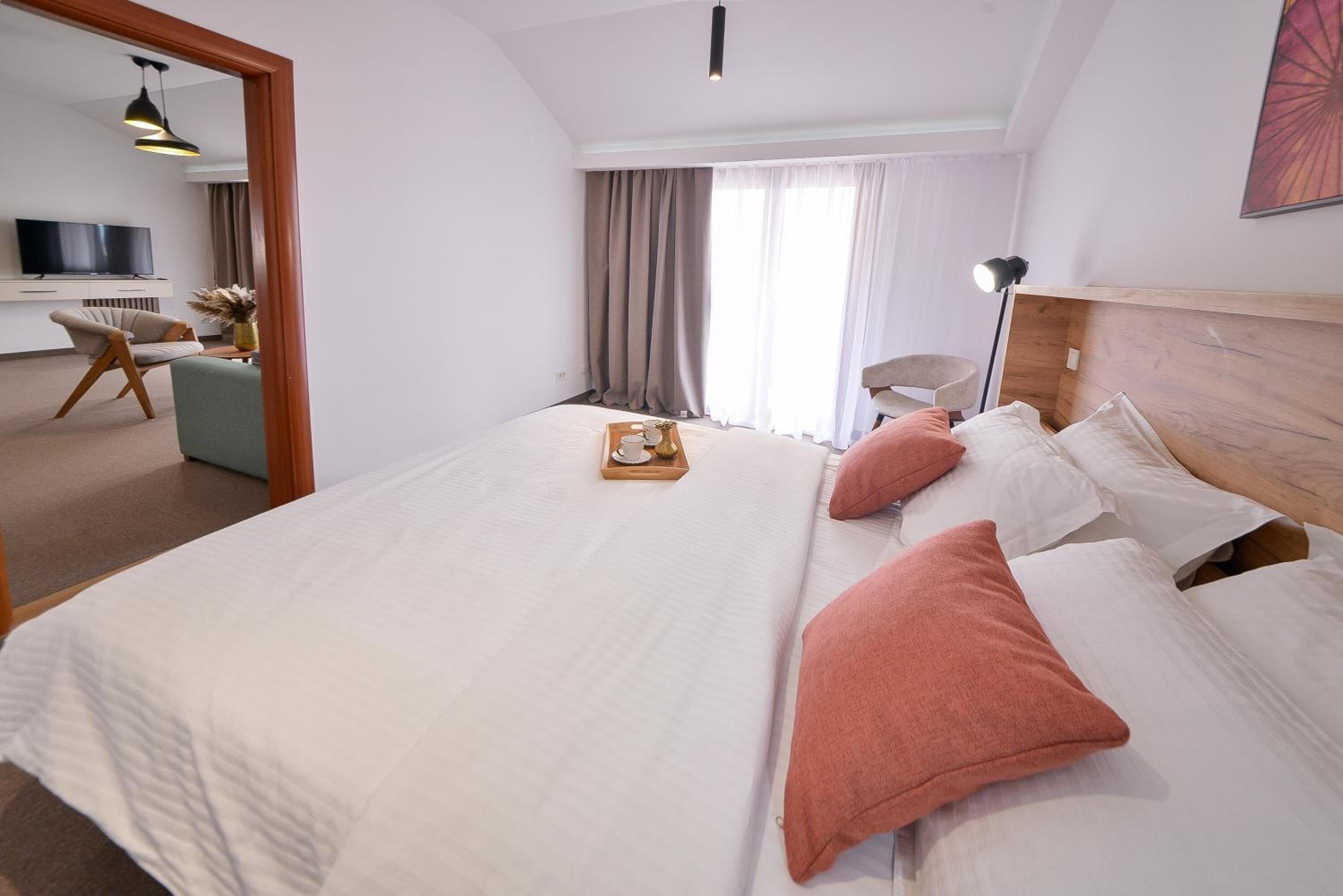 Ein Hotelzimmer mit einem großen Bett, einem Fernseher, einem Schreibtisch und einem Sessel.