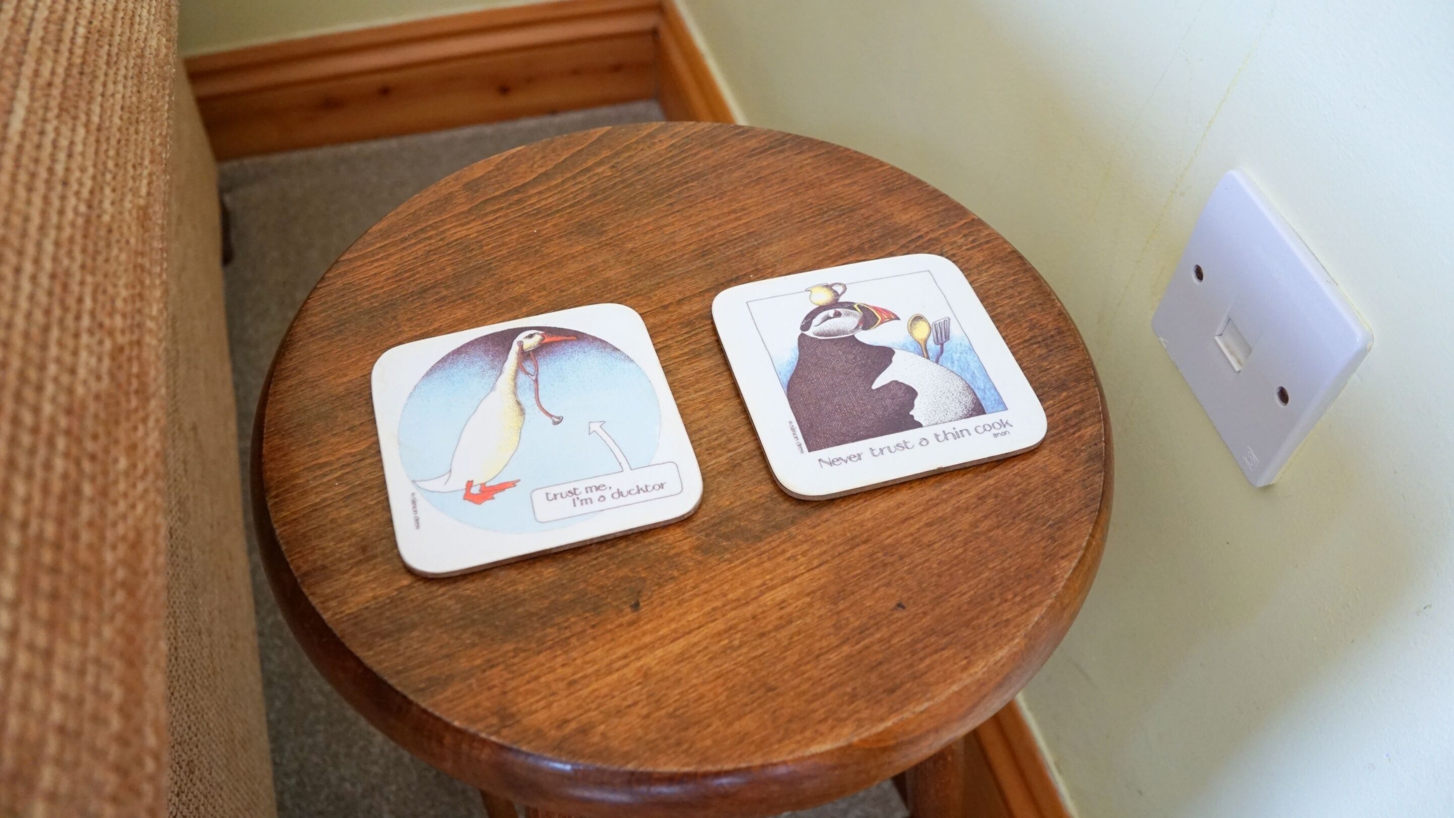 Two cards on a wooden table with a wall socket nearby.