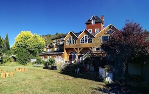 Un grand bâtiment en bois à plusieurs étages, doté d’une entrée centrale imposante et de nombreuses fenêtres.