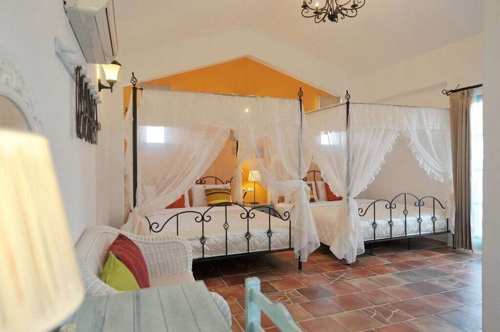 Un dormitorio con cama con dosel, una mesita de noche y una silla.