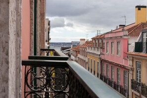Un balcón con vistas a edificios coloridos y un puente a lo lejos.