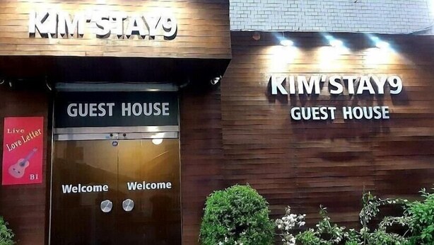 A guest house entrance with a wooden facade and a sign that reads "KIM'STAY9 GUEST HOUSE". - Kimstay9 (Seoul)