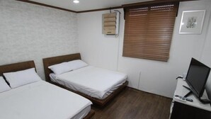 A hotel room with two single beds, a desk with a computer, and a window with blinds. - Kimstay9 (Seoul)
