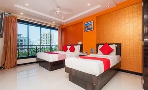 A hotel room with two beds, a large window, and a city view. - Fabhotel Panchvati Residency Andheri West (Mumbai)