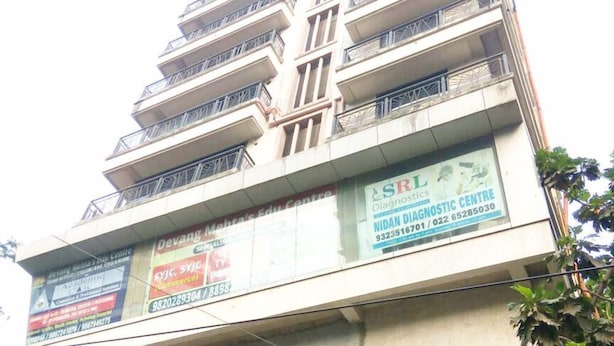 A multi-story building with balconies and several commercial signs on the ground floor. - Fabhotel Panchvati Residency Andheri West (Mumbai)