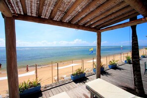 A wooden deck overlooking a beach with a clear view of the ocean. - Mar Paraiso Hotel (Porto Seguro)