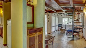 A spacious living area with a kitchen, a dining area, and a staircase leading to an upper level. - Mar Paraiso Hotel (Porto Seguro)