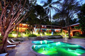 A resort with a swimming pool, lounge chairs, and a building with multiple balconies. - Mar Paraiso Hotel (Porto Seguro)