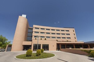 Un hotel moderno con fachada curva, varios pisos y un cartel que indica que es un hotel.