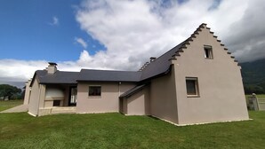 A modern house with a sloped roof, a chimney, and a small porch. - House with breathtaking view of the mountains (Adast)