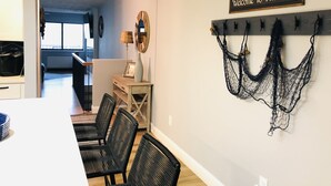 Un comedor con una mesa, sillas y un letrero en la pared que dice "Welcome To The Lake".