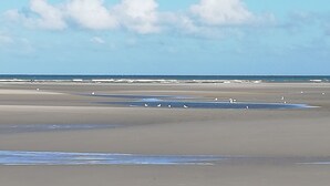 Una playa con amplias zonas de arena y mar tranquilo.