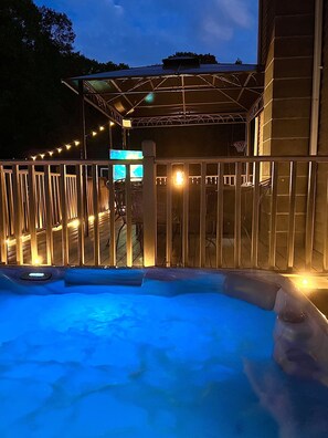 Ein Whirlpoolbereich mit Holzterrasse und überdachter Sitzgelegenheit.
