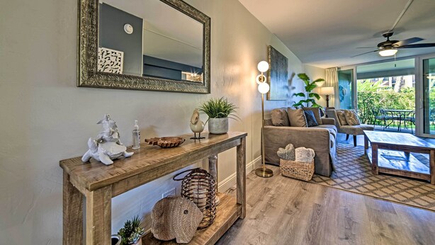 Een woonkamer met een houten console tafel, een grote spiegel en een bank.