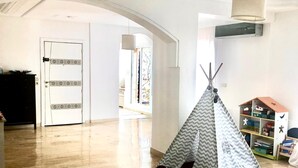 A spacious room with wooden flooring, a white door with decorative panels, and a large arched doorway leading to another room. - Appartement Spacieux et Ensoleillé Plein sud Avec Grande Terasse Sans vis a vis (Tangier)