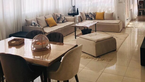 A spacious living room with a large sectional sofa, a dining table with chairs, and a ceiling fan. - Appartement Spacieux et Ensoleillé Plein sud Avec Grande Terasse Sans vis a vis (Tangier)