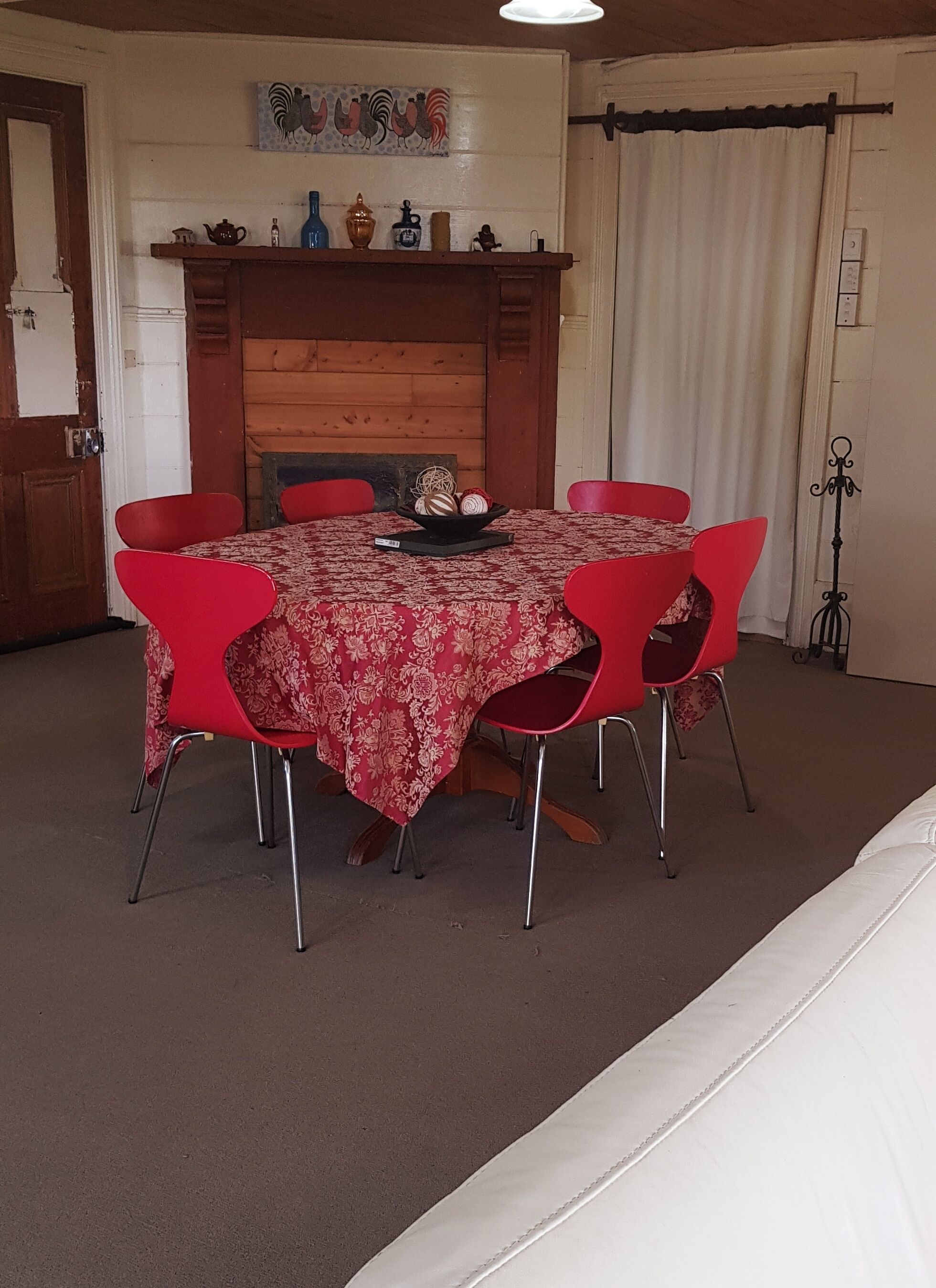 En matplats med ett bord täckt av en röd duk, omgivet av sex röda stolar.