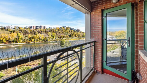 Un balcon donnant sur une rivière, avec des bâtiments en arrière-plan.
