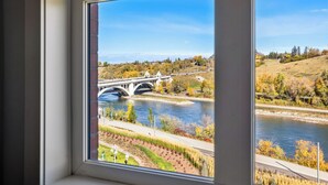 Une vue sur une rivière, un pont et le feuillage automnal.