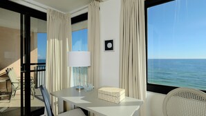 A balcony with a table, chair, and a view of the sea. - Broadmoor 503 Steps to the beach! Come make lasting memories! (Orange Beach)