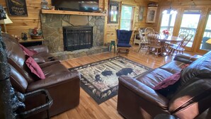 A cozy cabin interior with a stone fireplace, leather furniture, and a wooden ceiling. - New Hot Tub, Outdoor Bar, Family Friendly, Awesome Views, Golf, Bears, Pool (Gatlinburg)