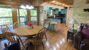 A wooden cabin interior with a dining area, kitchen, and living space. - New Hot Tub, Outdoor Bar, Family Friendly, Awesome Views, Golf, Bears, Pool (Gatlinburg)