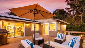 An outdoor deck with wicker furniture, a barbecue grill, and a large umbrella. - Serene Canyon Private Villa•Pool•HotTub•Sauna Retreat STR Permit Number:14614552 (Pacifica)