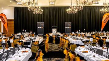 A banquet hall with rows of tables set for a formal event, each with name cards and place settings.
