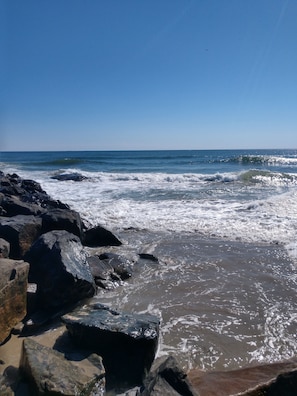 A rocky shoreline with waves crashing onto the beach.