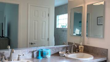 Tina con regadera, toallas, jabón, papel de baño