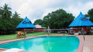 A swimming pool with a blue-roofed pavilion and a small play area. - Stunning 3-Bed House in well Secured Estate, Lekki (Awoyaya, Ibeju Lekki LG.)