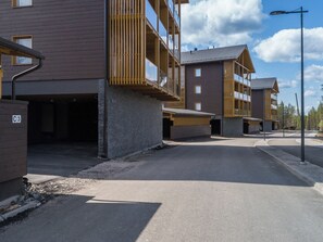 Een modern gebouw met meerdere balkons en een overdekte parkeerplaats.