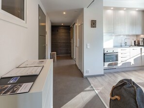 Une cuisine moderne dotée d’appareils électroménagers en acier inoxydable, d’un plancher en bois et offrant une vue sur l’espace de vie.